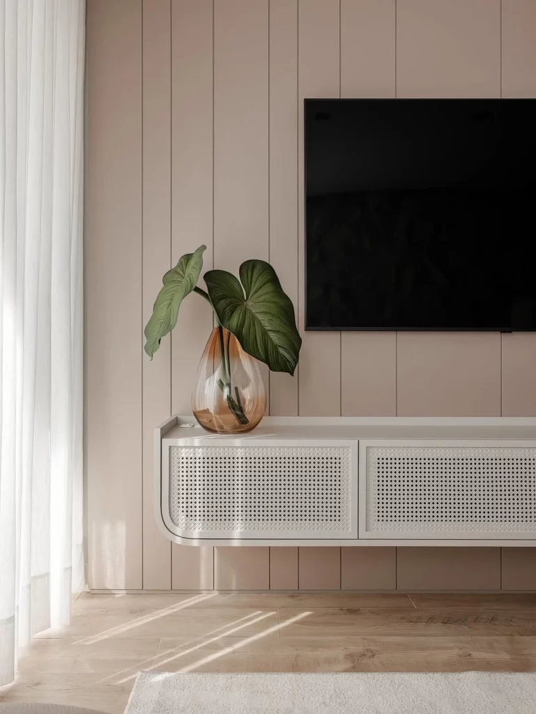 Rack suspenso branco com um vaso de vidro e planta.