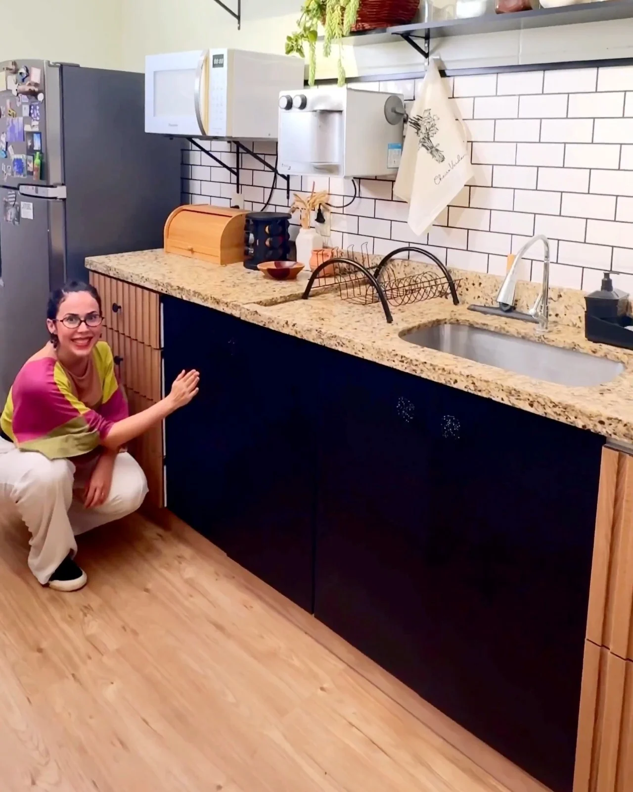 Armários com portas pretas e gavetas ripadas.