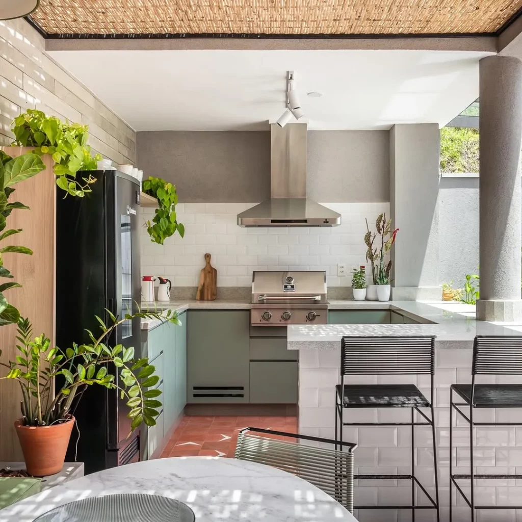 Cozinha planejada em área gourmet com formato de U.