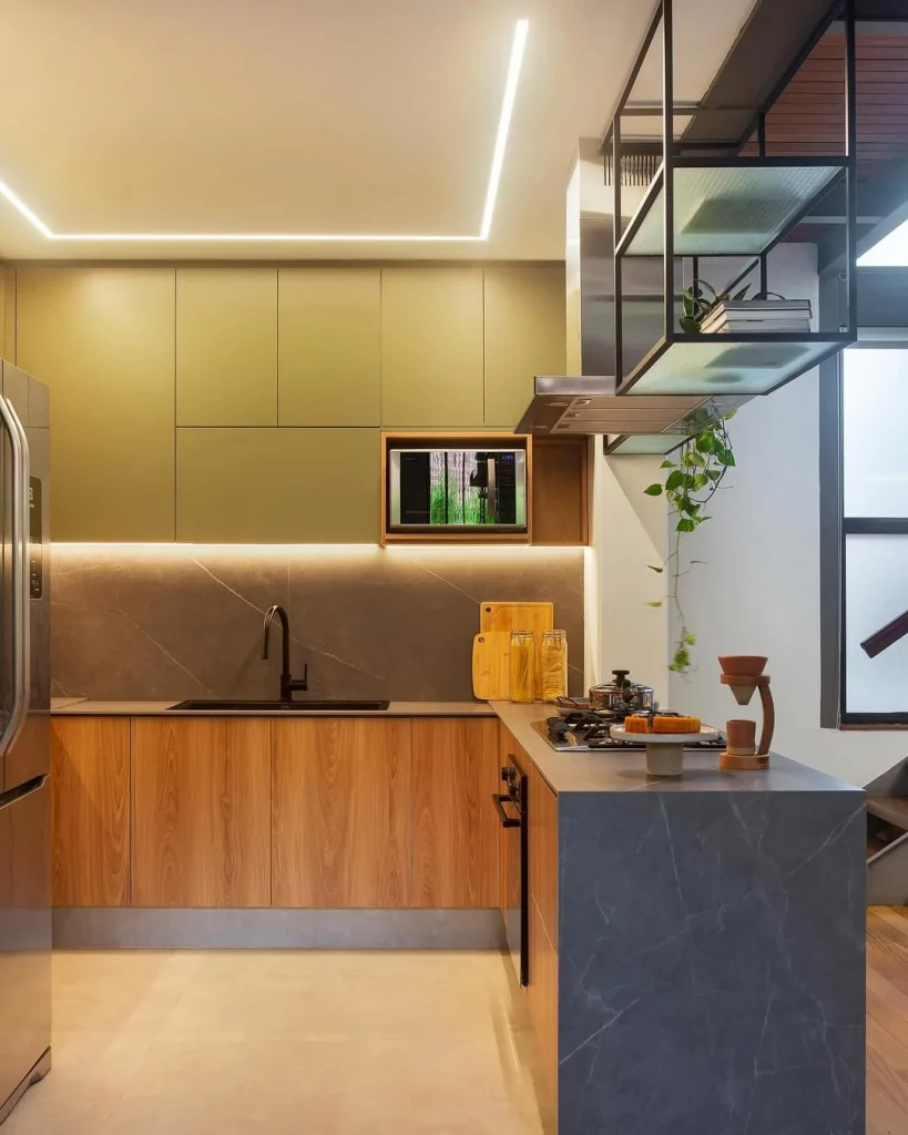 Cozinha planejada com bancada em formato de L e iluminação.