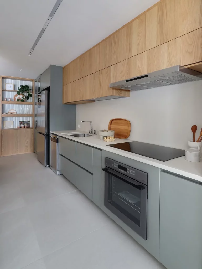 Cozinha planejada com bancada branca e armário acinzentado.