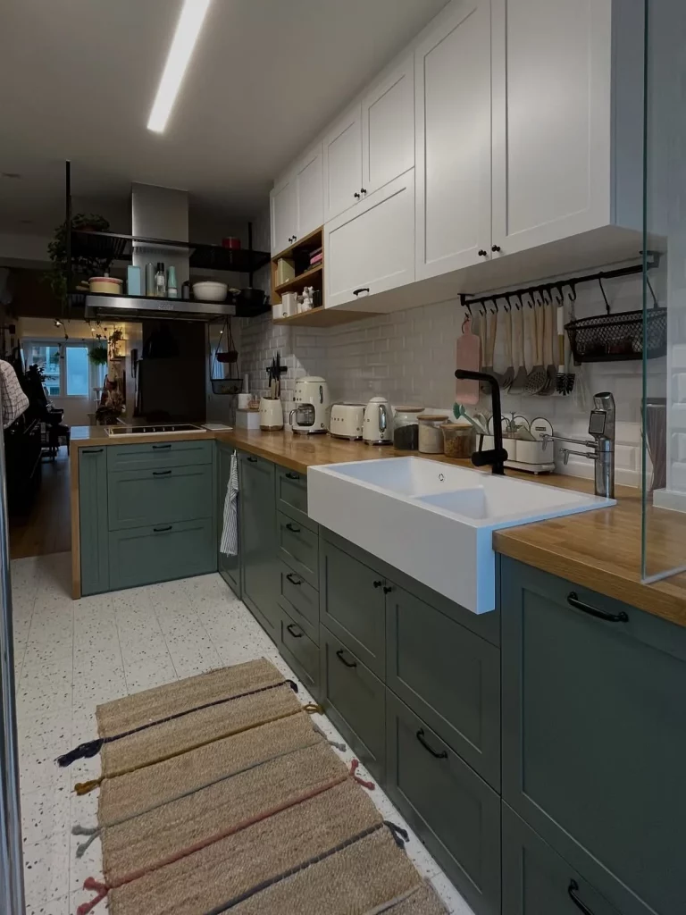 Cozinha com bancada de madeira e armário escuro.