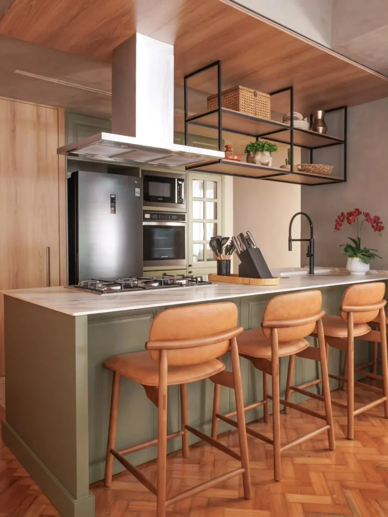 Bancada de cozinha de pedra natural e fundo verde, bancos de couro e madeira.