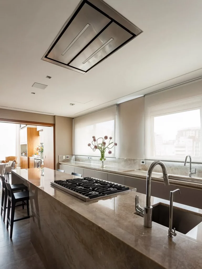 Cozinha com bancada extensa e de mármore.