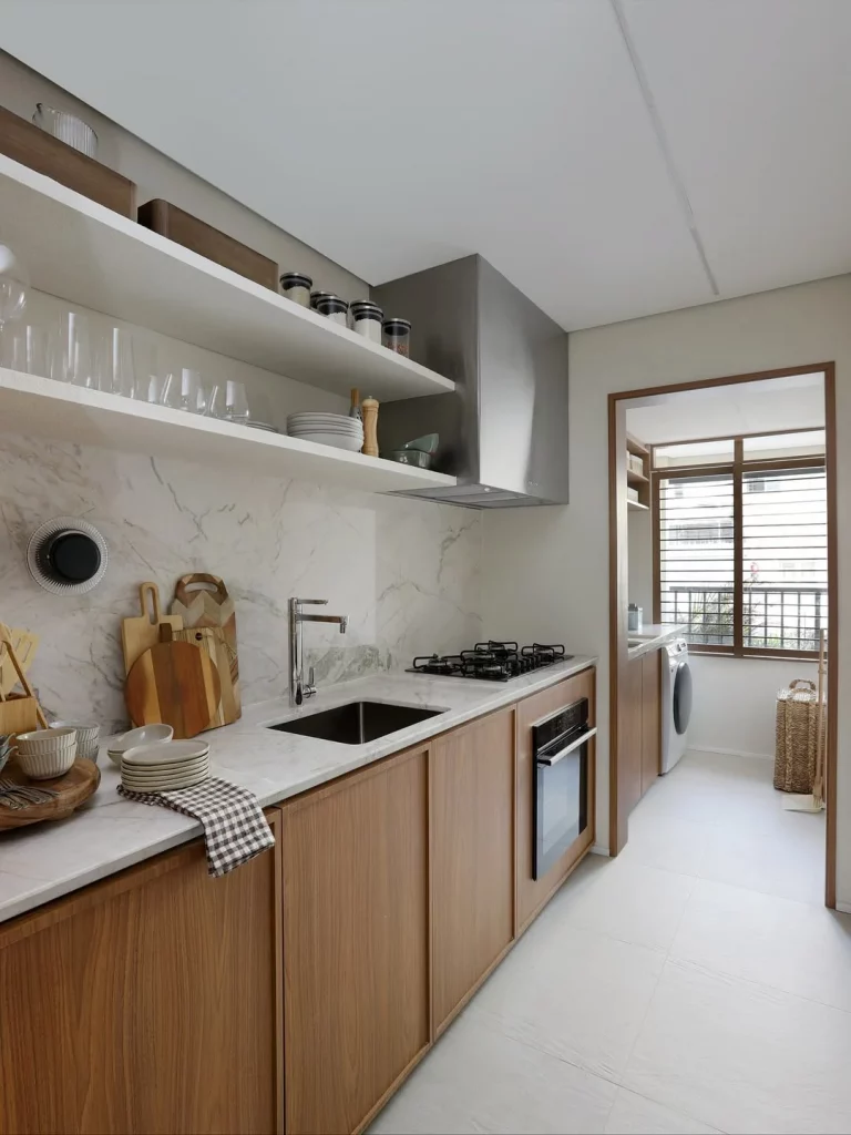 Cozinha ampla com bancada linear e branca.