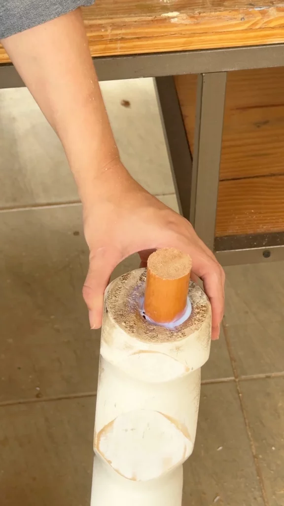 Cabo de vassoura de madeira como cavilha gigante.