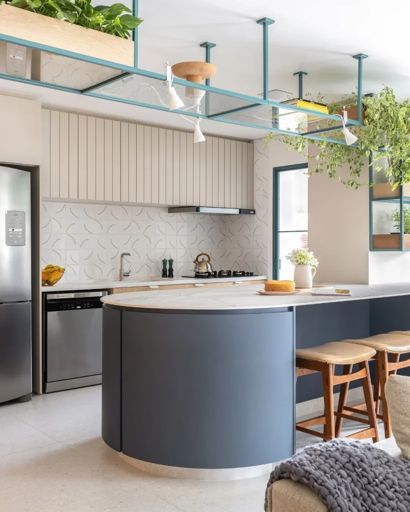 Cozinha planejada com aspecto moderno e arredondado, ilha azul.