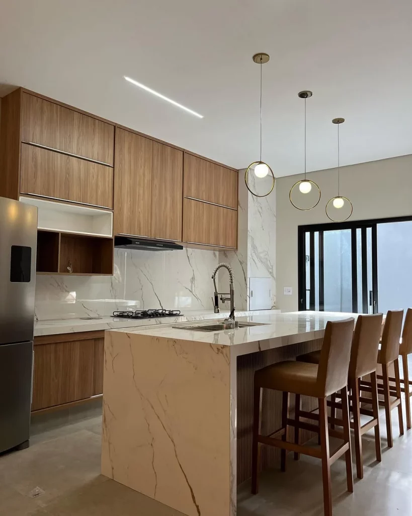 Cozinha com bancada de mármore e armários de madeira.
