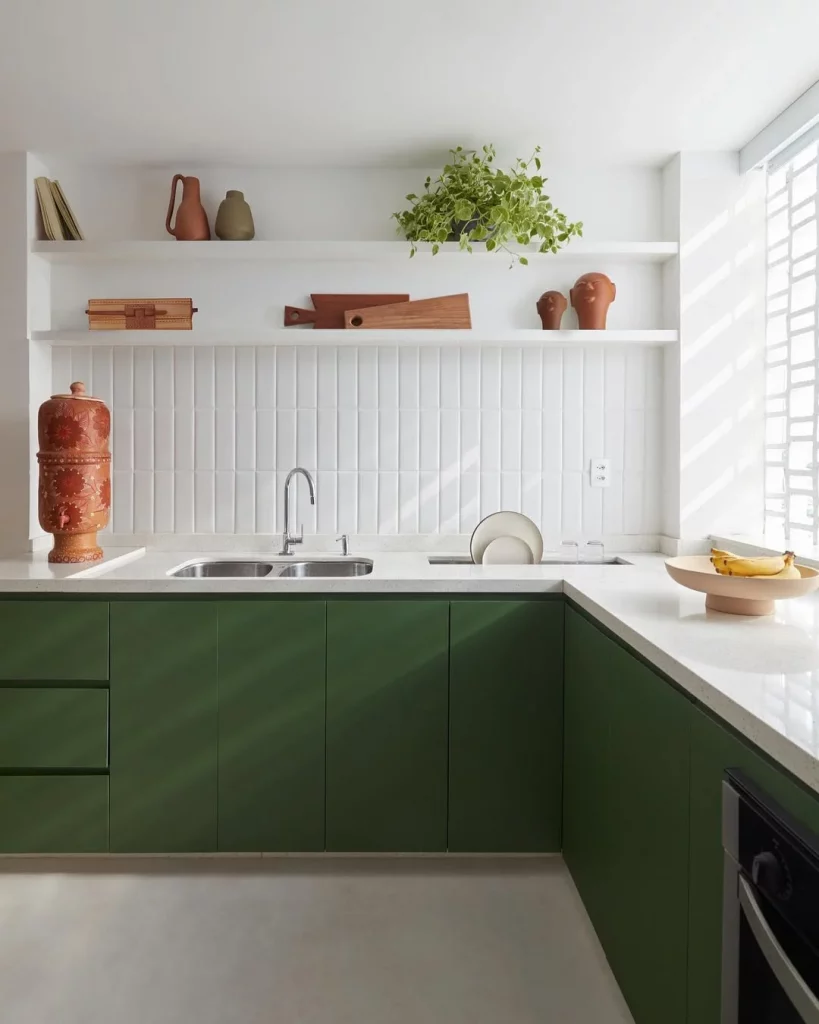 Cozinha planejada com bancada em formato de L e armário verde.