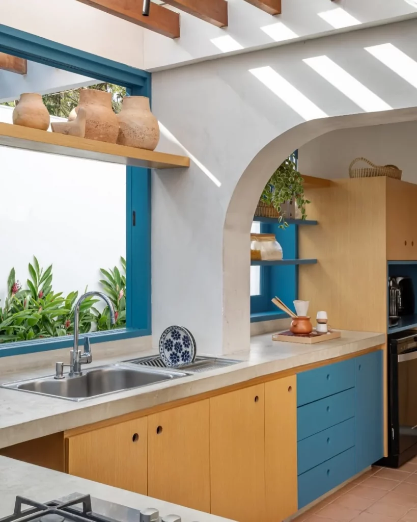 Bancada planejada branca com espaço para secar louça e armários coloridos na cozinha.