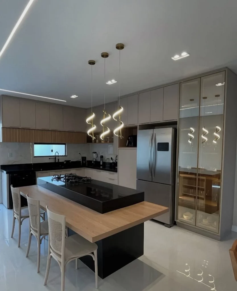 Cozinha planejada com pêndulo moderno e luz amarela.