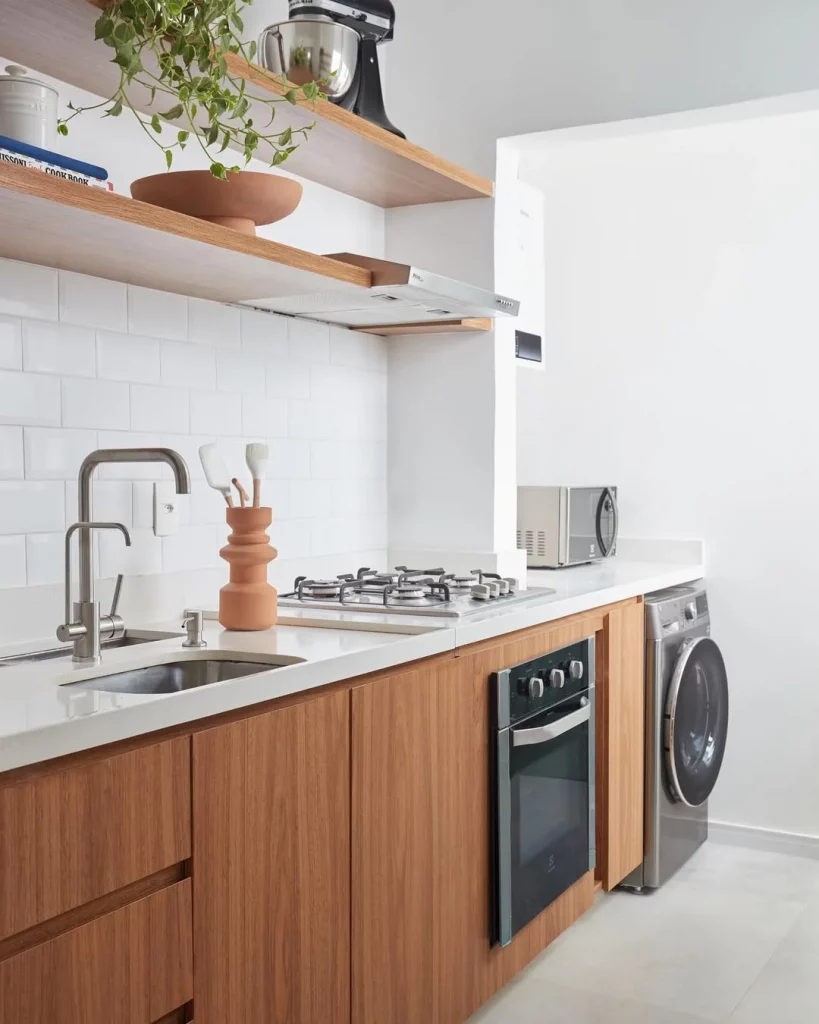 Bancada de cozinha com armário de madeira e cooktop.