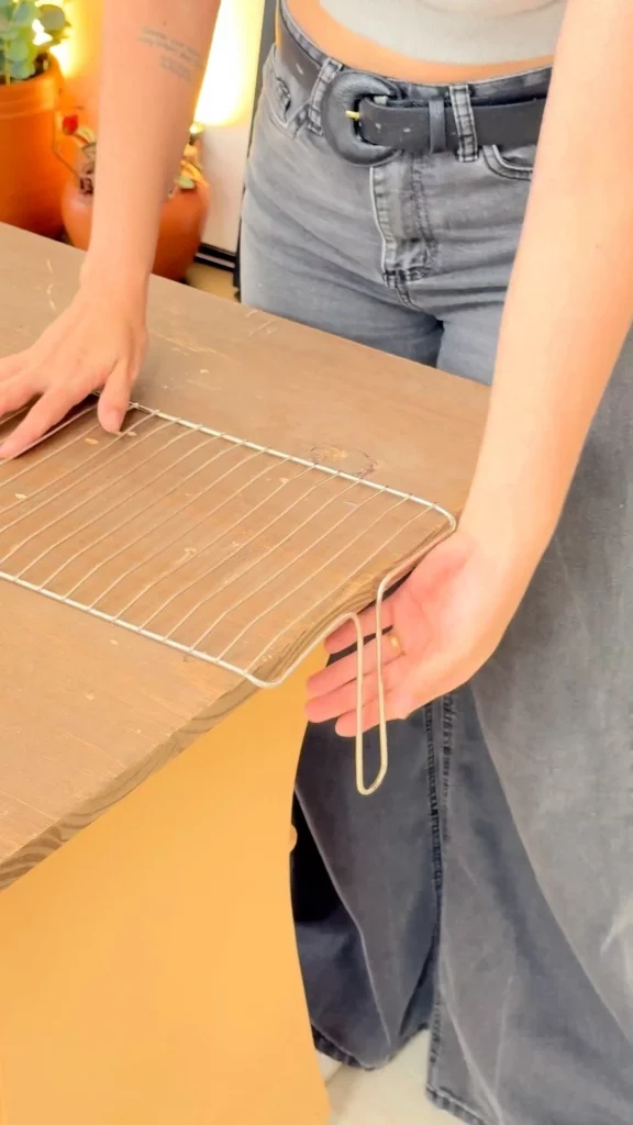 Entortando o puxador da grelha de churrasco na mesa.