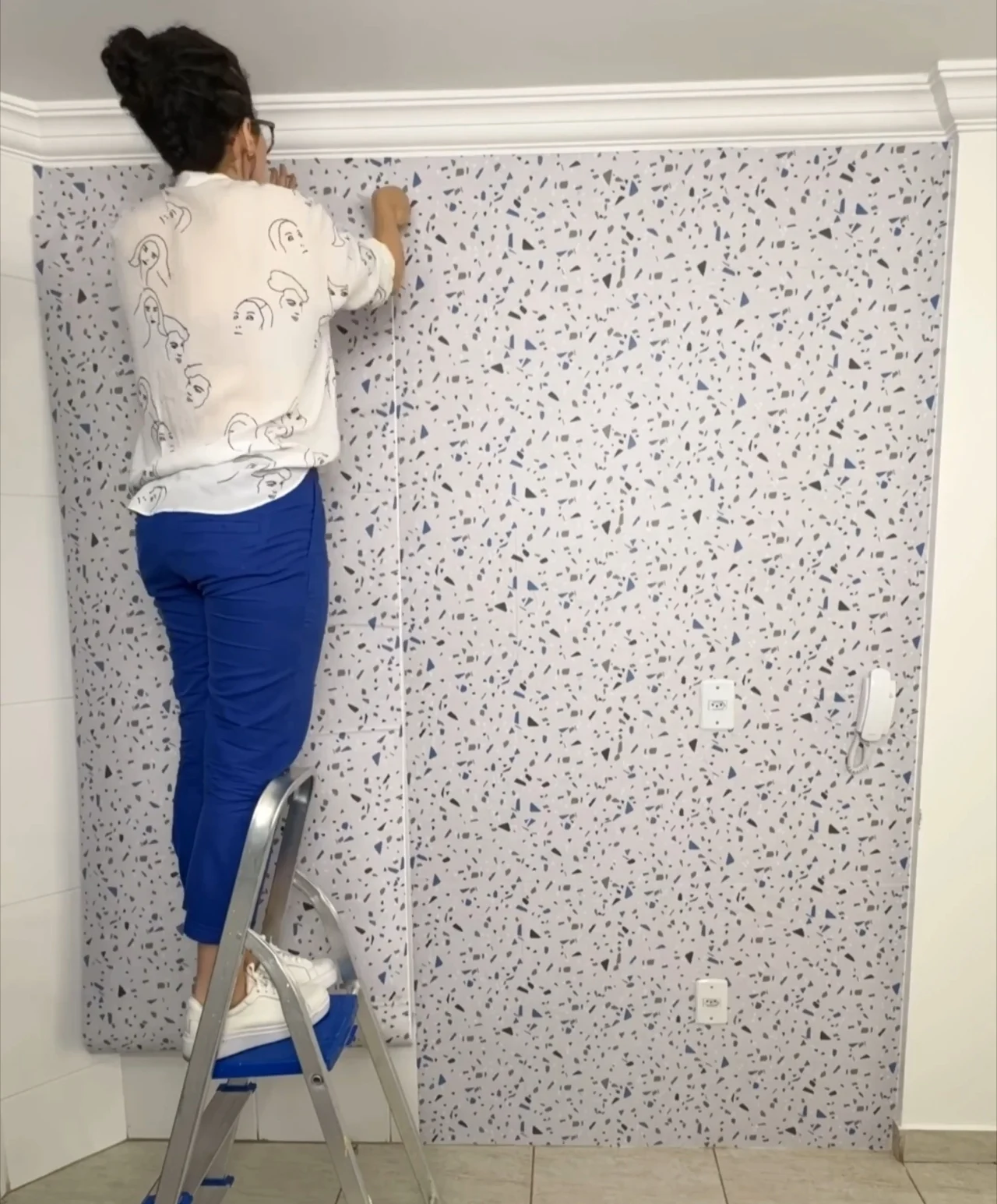 Instalando papel de parede granilite na parede da cozinha.