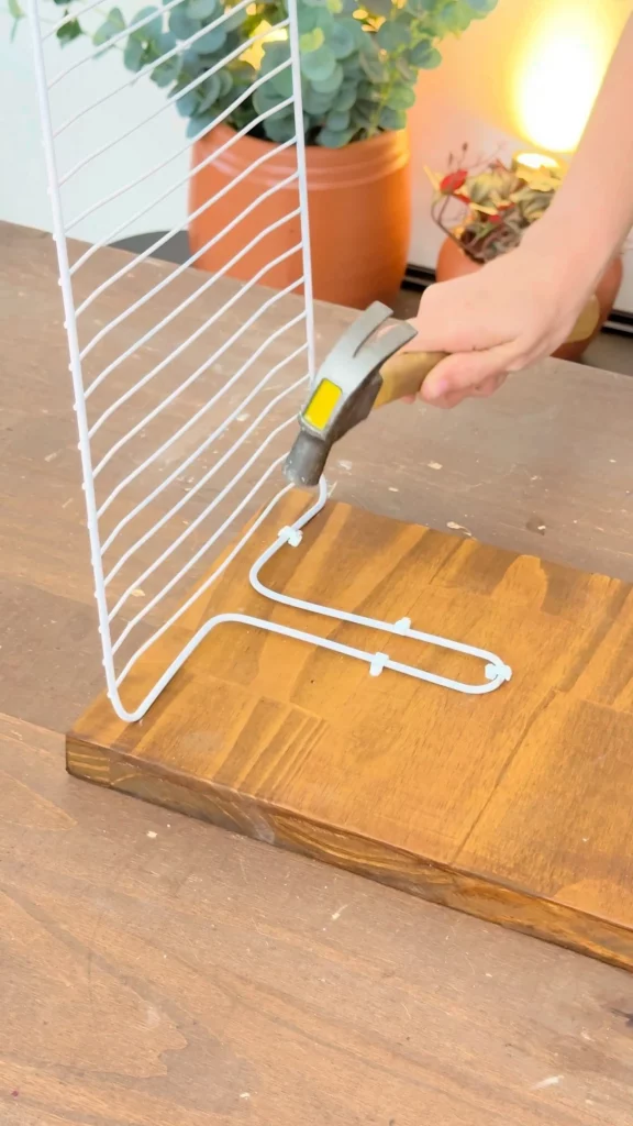 Fixando a grelha com fixa fio na tábua de madeira.