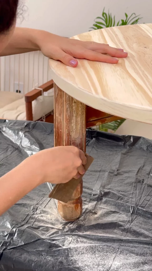 Lixando os pés da mesa de madeira.