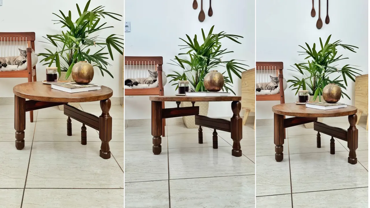 Mesa de centro vintage feita de madeira, planta no fundo e enfeite de bola metalizada.