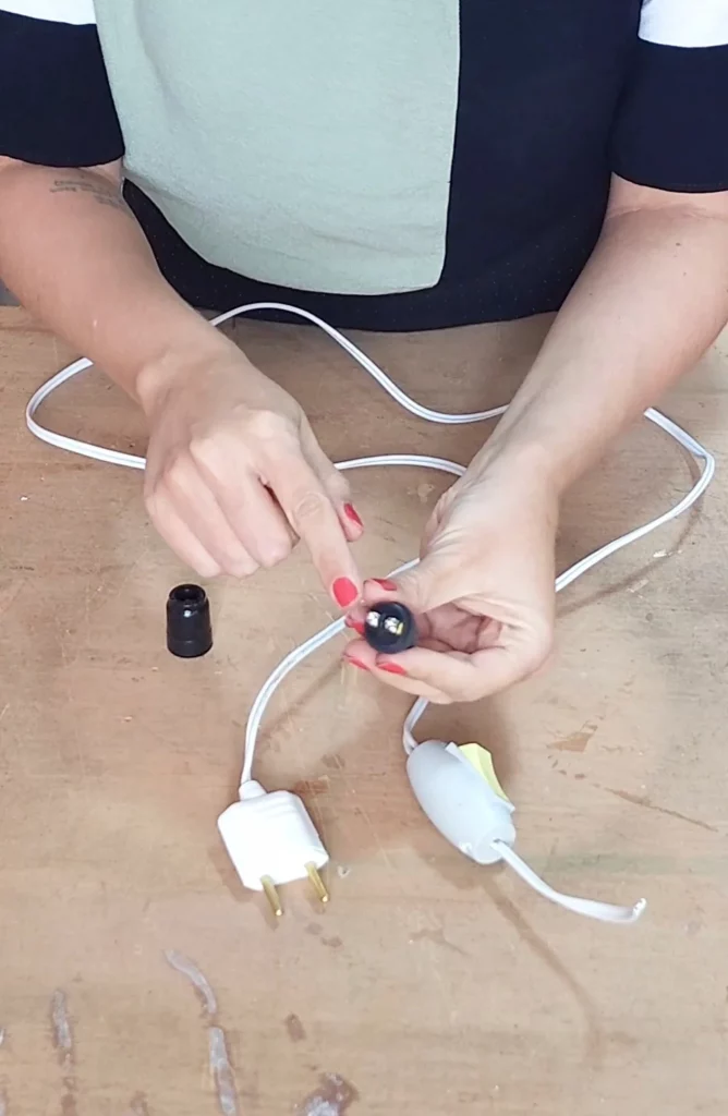 Mostrando o parafuso no soquete, mesa de madeira.