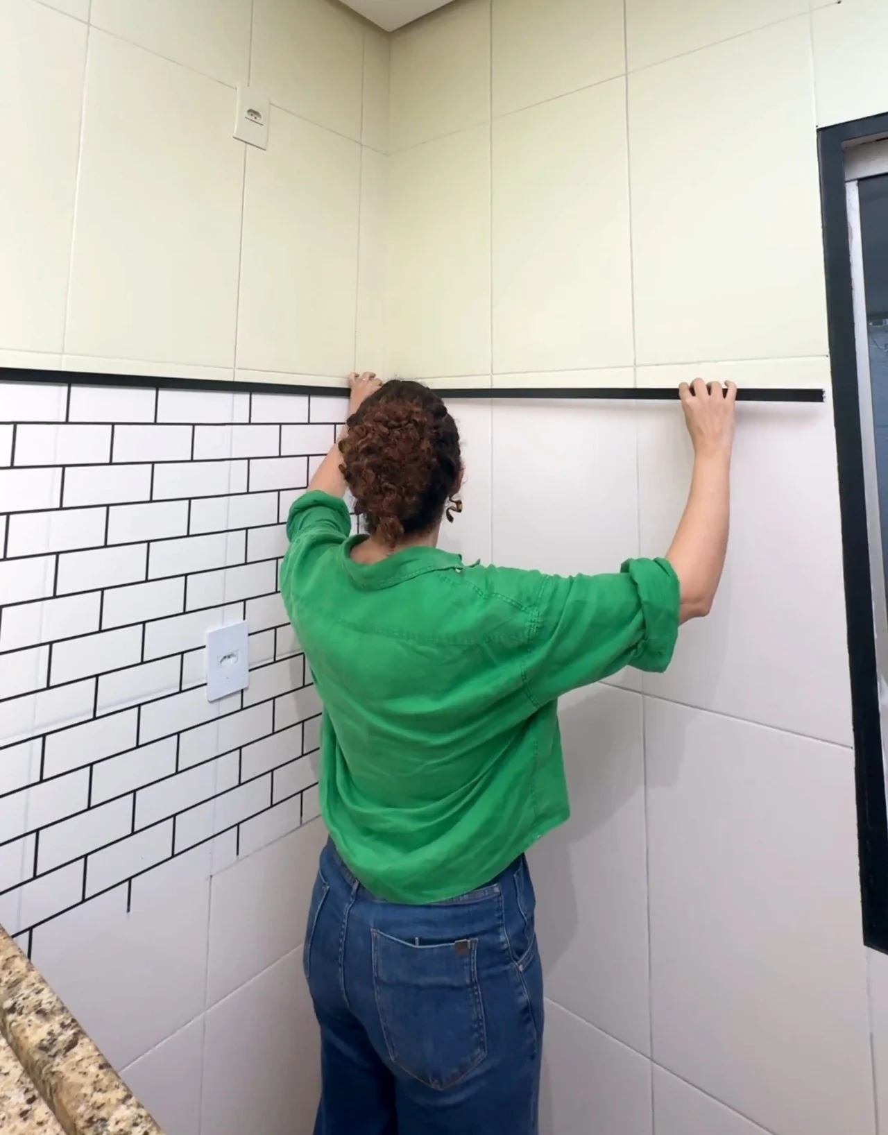 Parede de tijolinhos e metade com pintura verde claro.