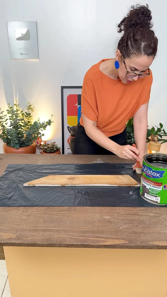 Aplicação do stain com pincel sob a lona preta.