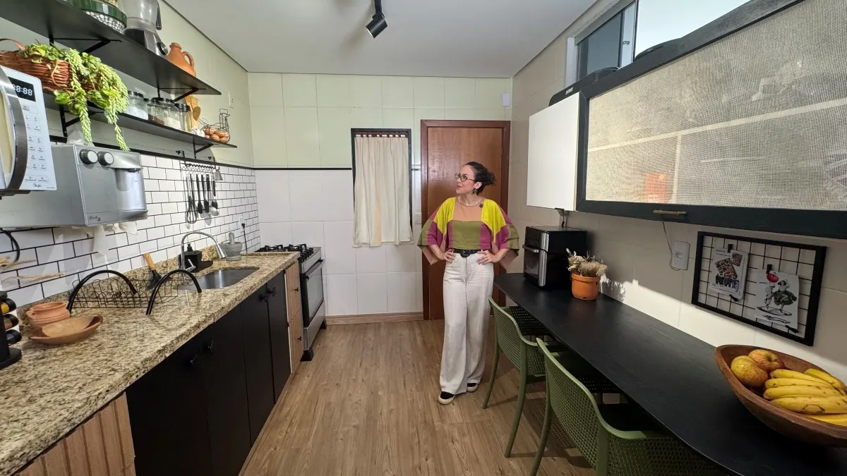 Cozinha alugada transformada, parede de tijolinhos com verde, cortina, mesa de estação de refeições rápida e cadeiras verdes.