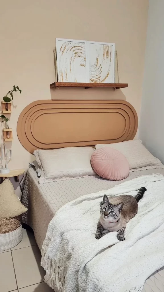 Cabeceira de cama bege escuro com rodameio adesivo em formato de arco arredondada.