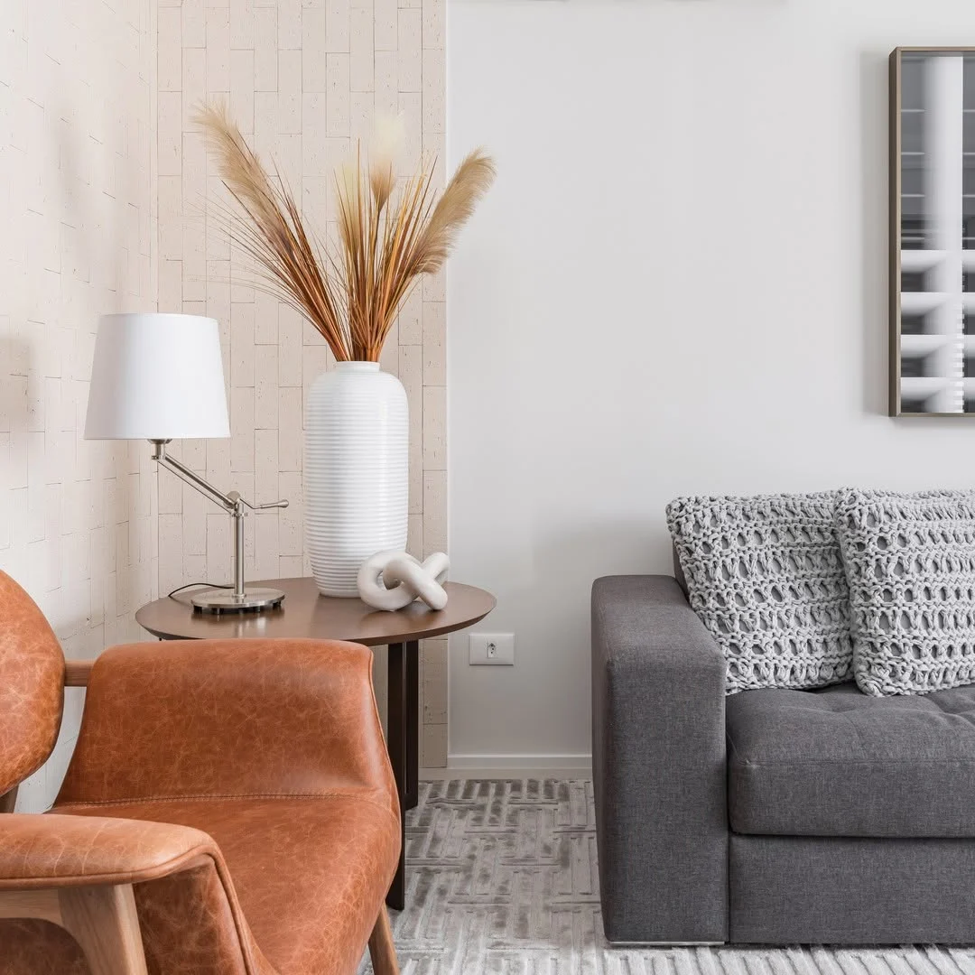 Combinações de cores cinza, caramelo e off white na sala, planta seca no vaso.