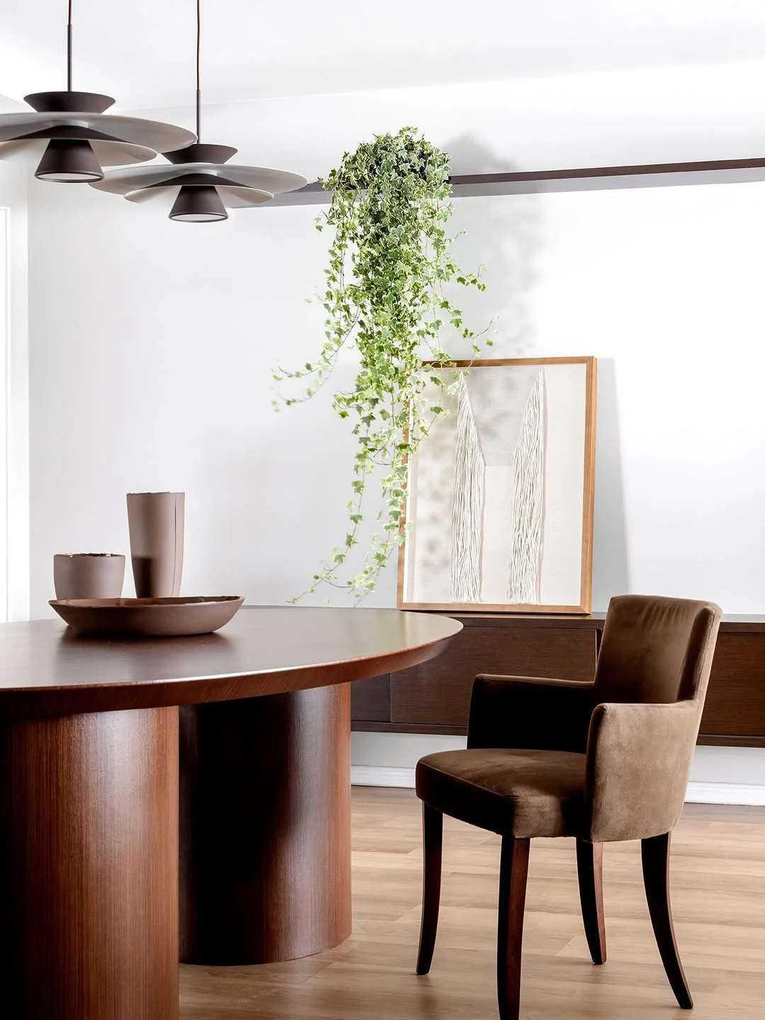 Sala com verde oliva na planta, cadeiras e meia parede marrom chocolate e quadro com tom de areia.