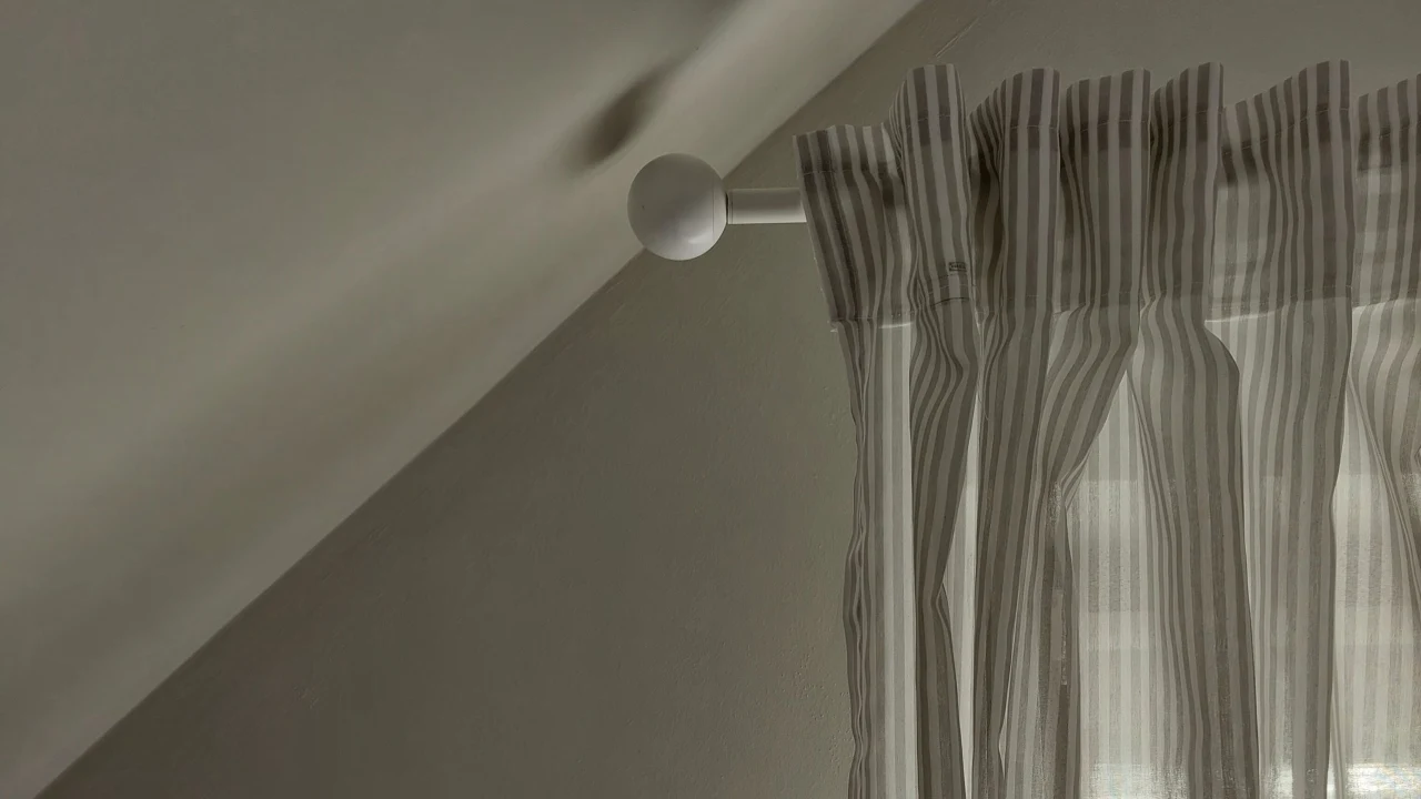 Varão de cortina branco e ponta arredondada.