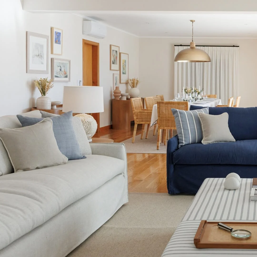 Sofás claro e azul marinho, almofadas em tons complementares.