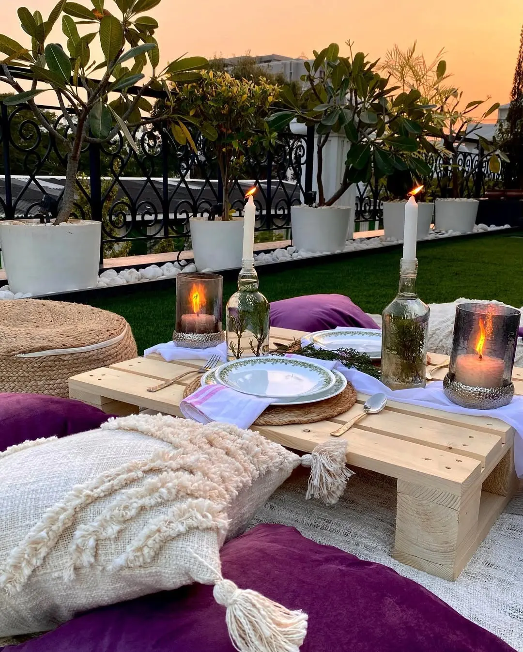 Pallet de madeira em ambiente externo e piquenique, mesa baixa e acessórios roxos.