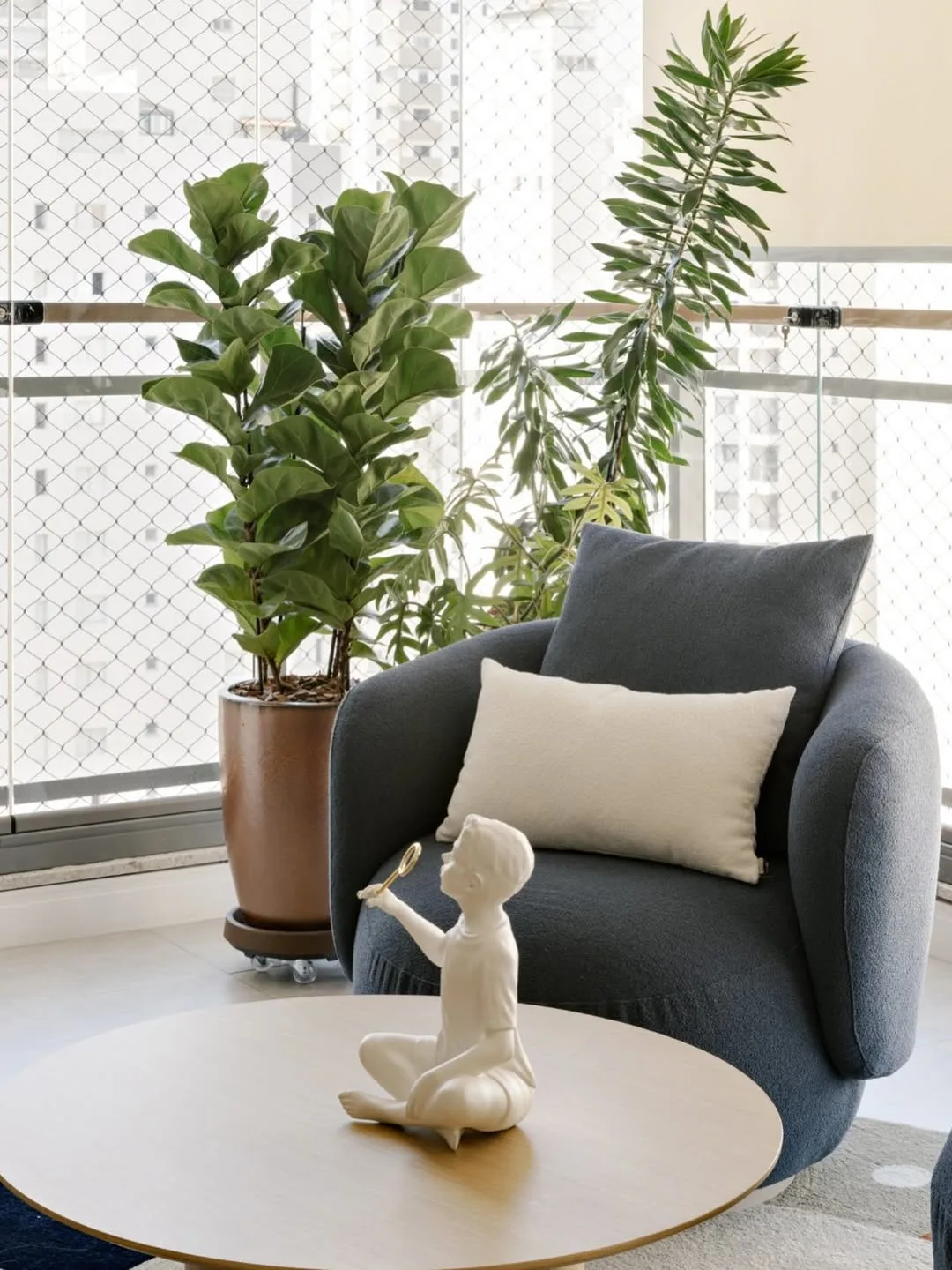 Poltrona azul marinho com almofada retangular branca dando alto contraste.