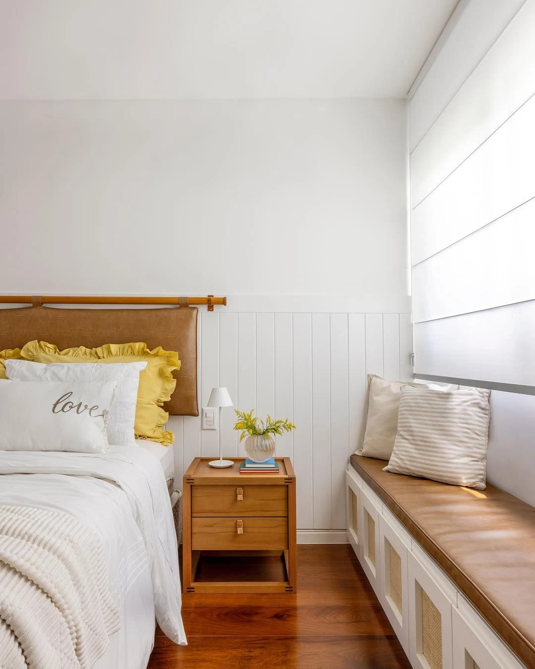 Quarto com almofadas com babado, bordadas e em formatos diferentes.