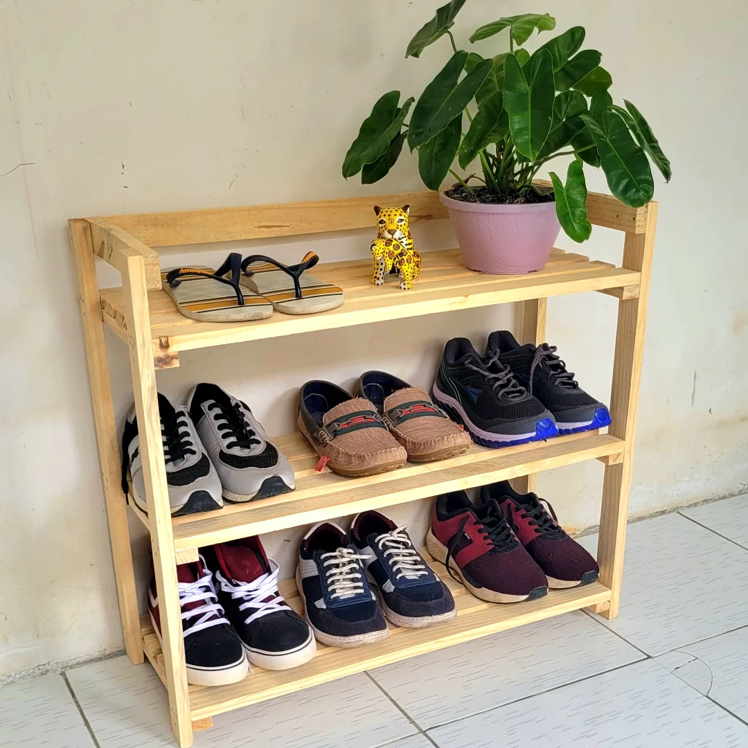Sapateira feita de pallet, sapatos apoiados, planta e mini onça.