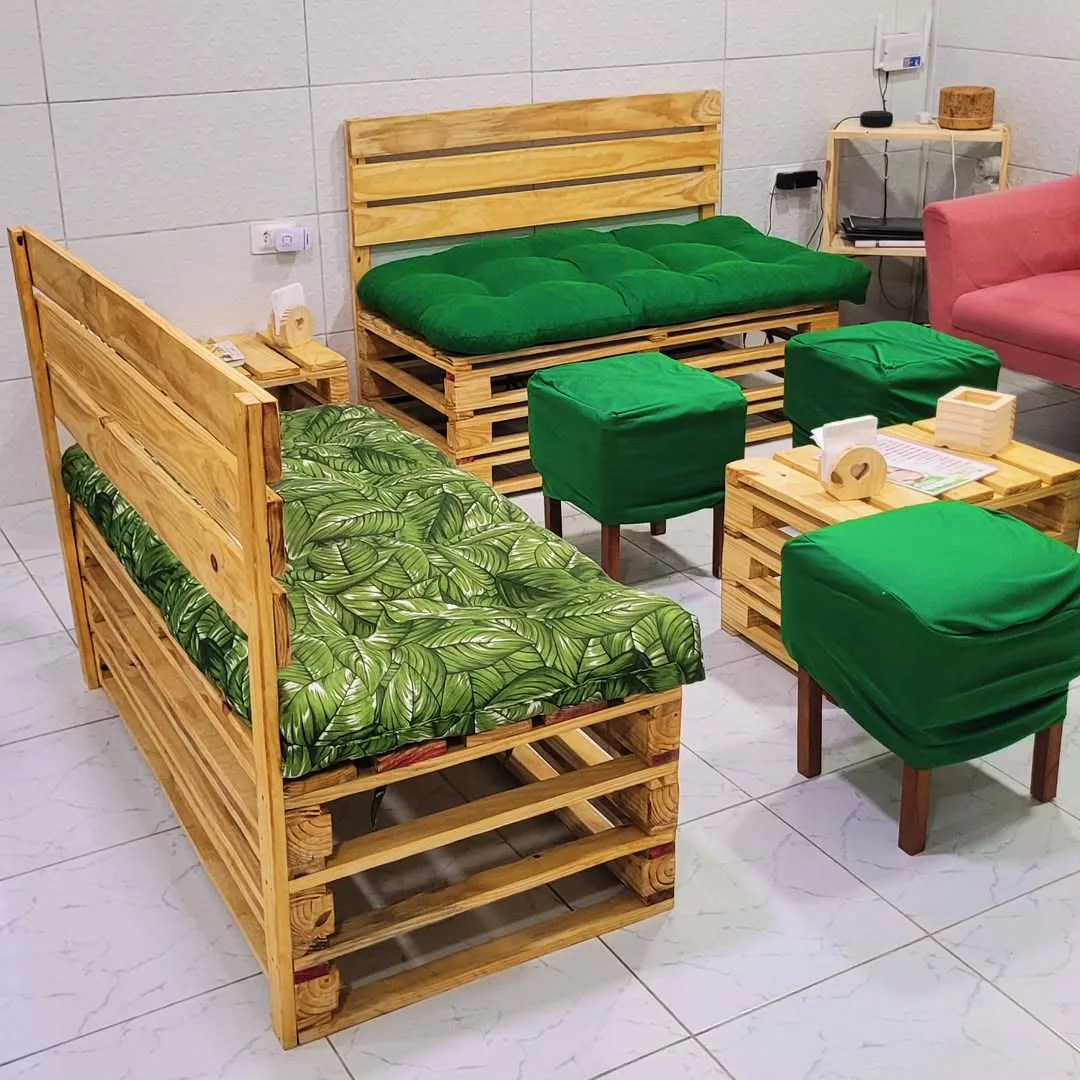 Sofá com almofada tropical e verde chamativo feito de pallet.