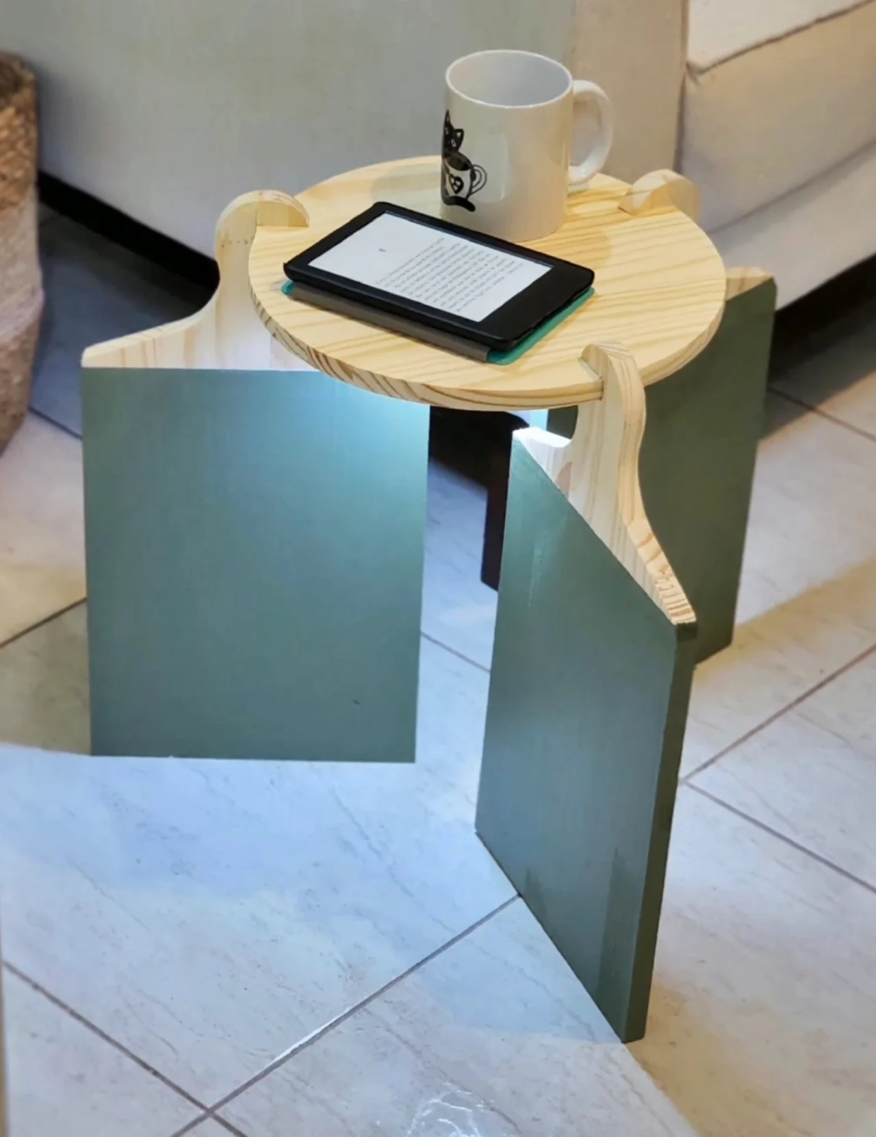 Mesa de centro feita com tábuas de madeira de cortar canre, base pintada de verde musgo e luz de spot.