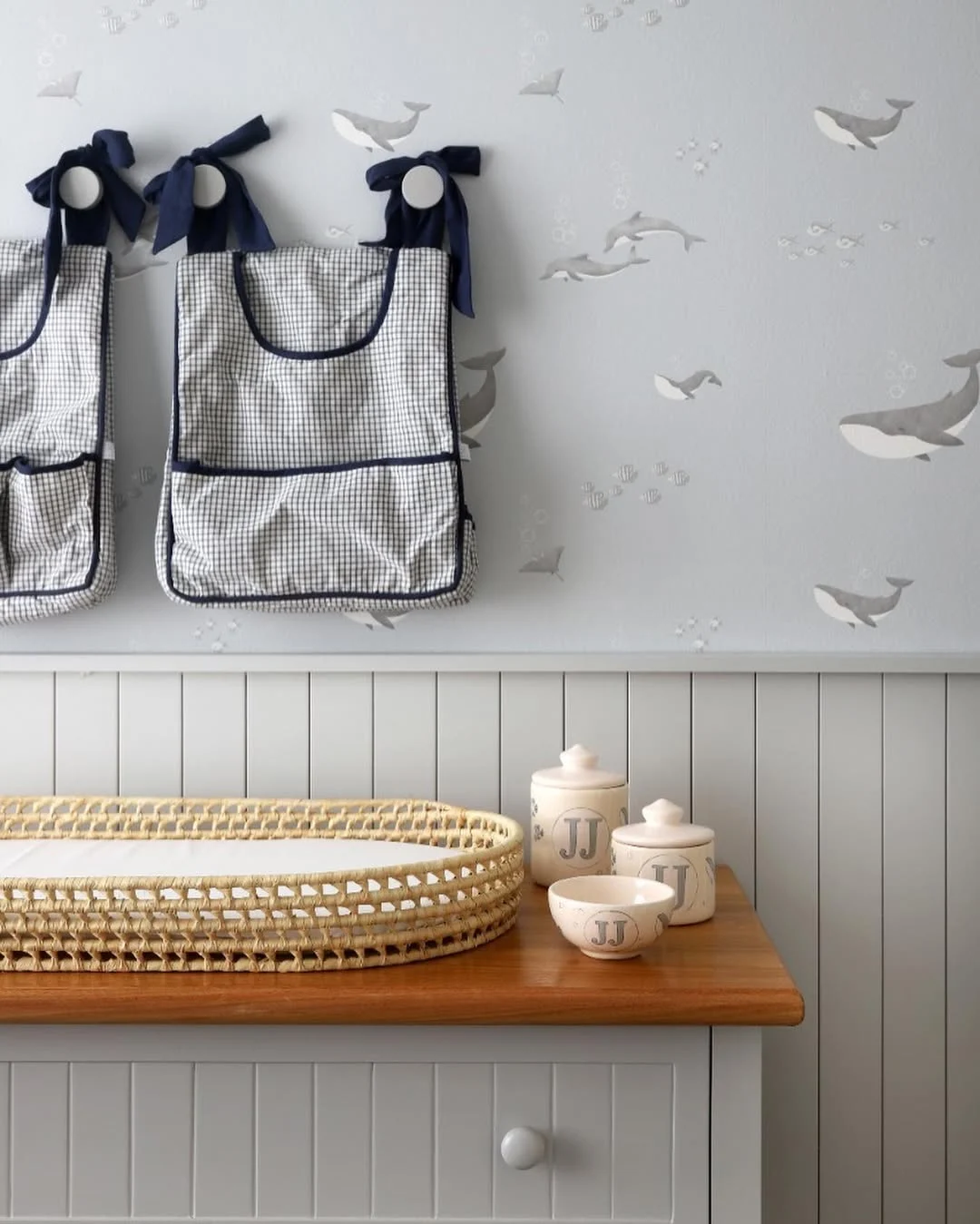 Quarto de criança com papel de parede de baleia, trocador de fibra natural.