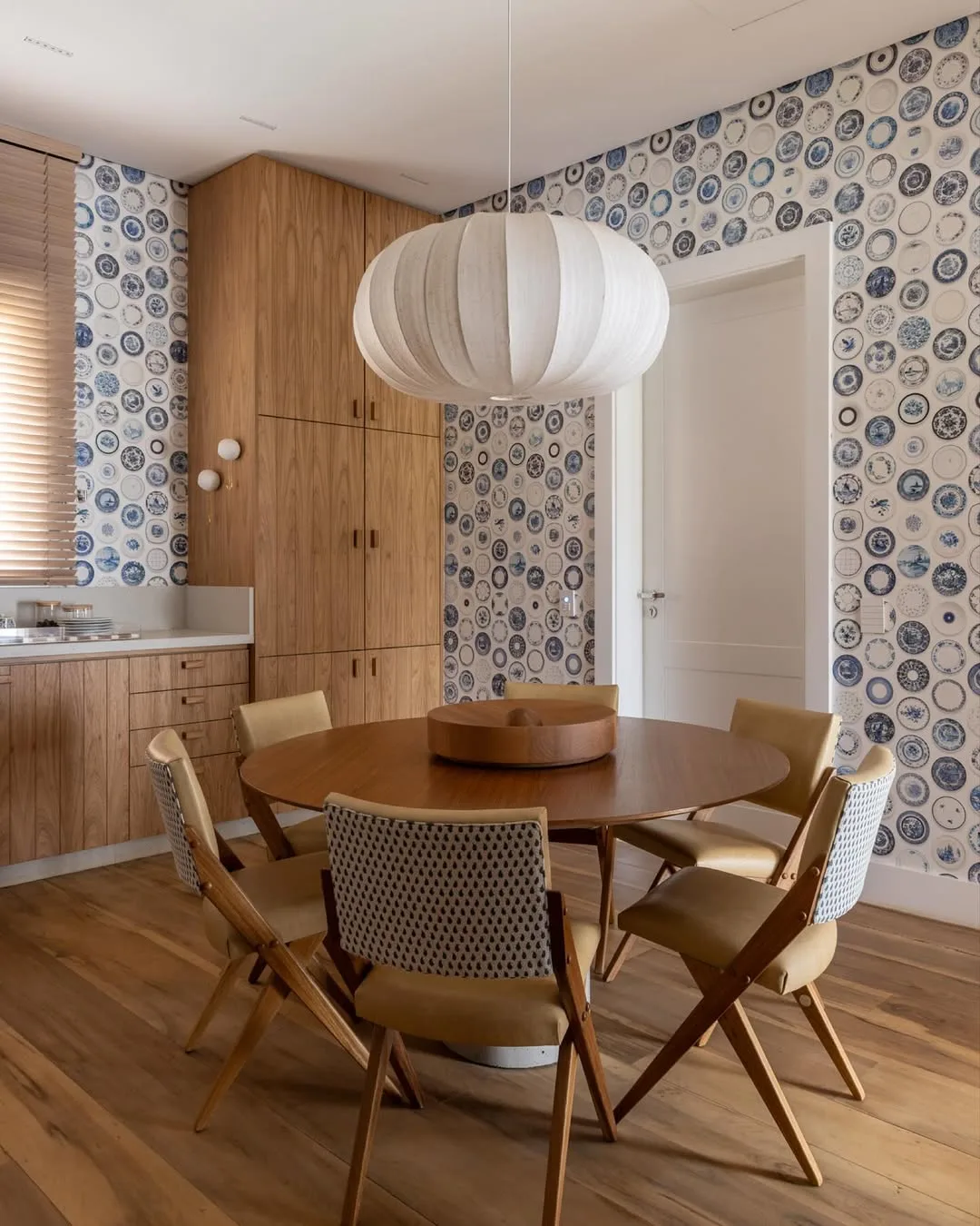 Cozinha e sala de jantar conjugada com papel de parede azul e branco de louça.
